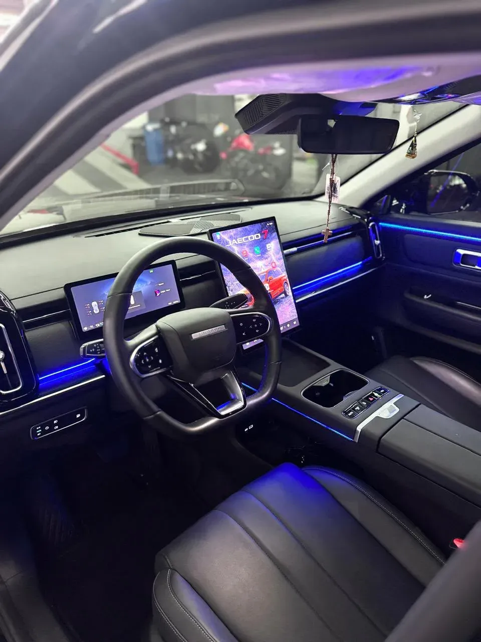 Jaecoo 7 com iluminação ambiente azul no painel, nas portas e no console
