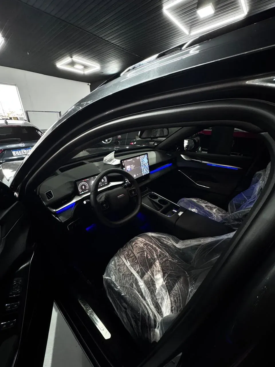 Interior de SUV GWM com linhas de luz azul no painel e nas portas